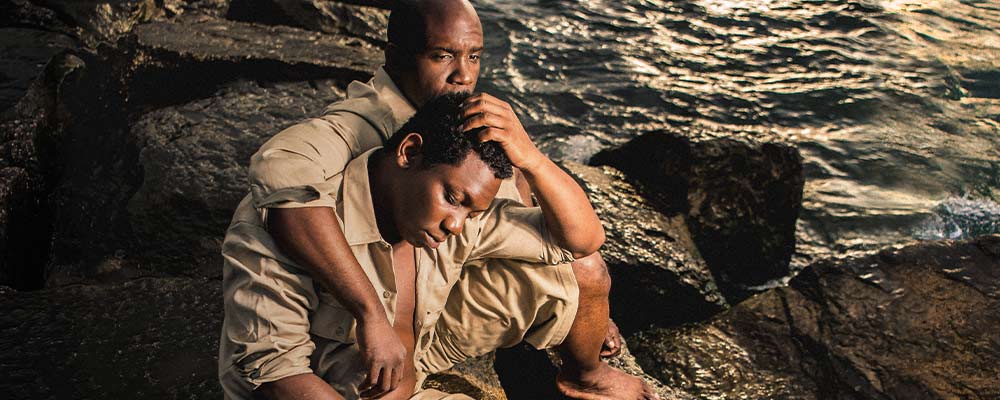 Photo of Ronald L. Conner and Kai Ealy sitting on a rock next to Lake Michigan at Promontory Point (Joe Mazza)