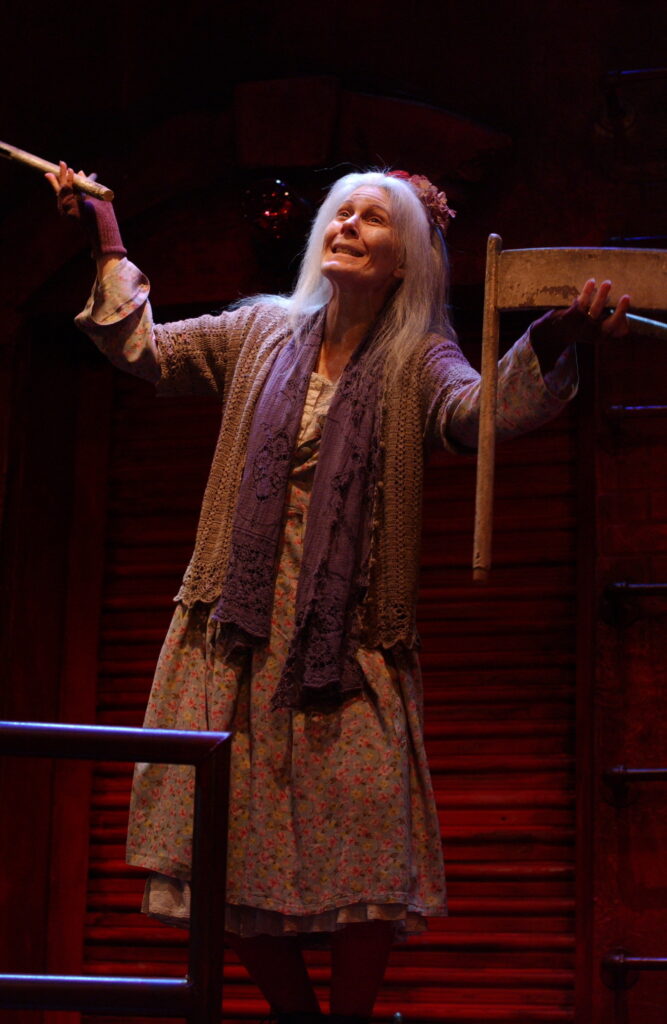 A woman looks to the sky and holds part of a chair.