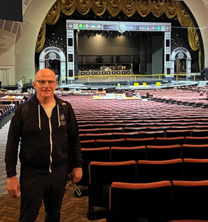 Artistic Director Charles Newell stands in the aisle at Radio City Music Hall.
