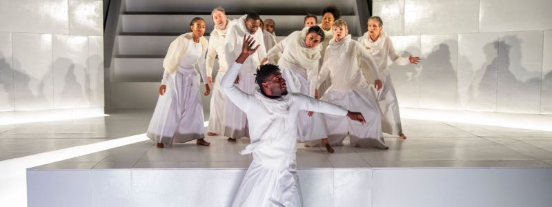 A group of people in white look surprised. They are standing in a clump.