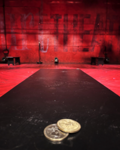 Two coins on a bench in an empty theatre.