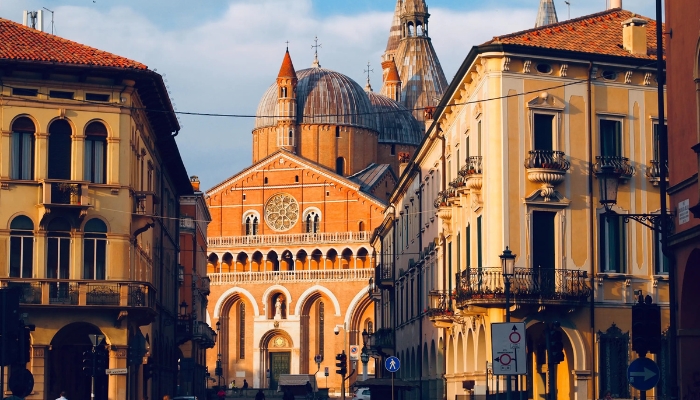 A photo shows yellow and orangey buildings with terracotta roofs and a large domed church.