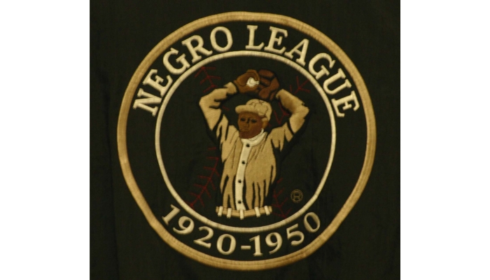 A patch, in the middle is a black player pitching. Around him are the words Negro League, nineteen twenty to nineteen fifty.